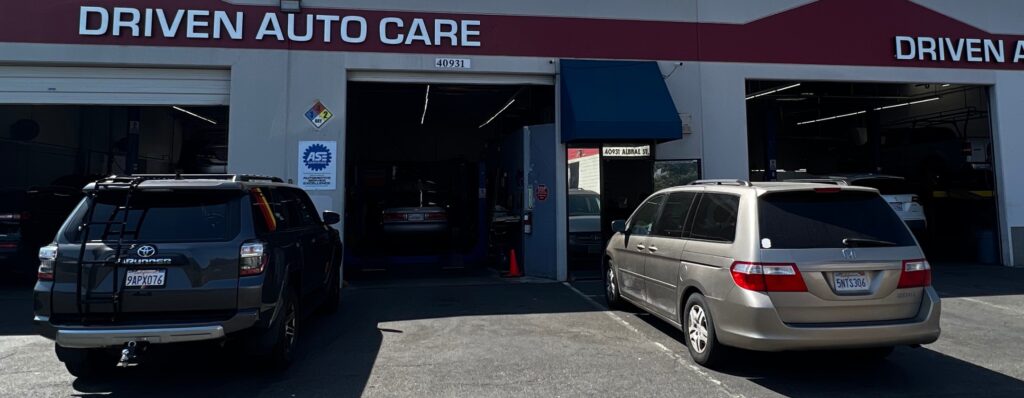 Japanese Auto Repair and Maintenance Services in Fremont, CA with Driven Auto Care. Image of a black Toyota car and Honda parked outside the Driven Auto Care shop, waiting for preventative maintenance.