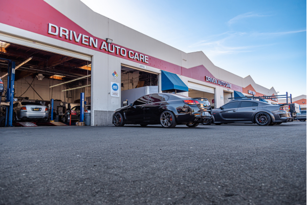 Driven Auto Care in Fremont, CA: A modern auto repair shop with a clean exterior and high-end vehicles being serviced, symbolizing trust, quality, and customer satisfaction in automotive care.