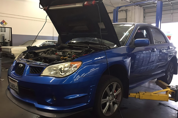 Independent Subaru Repair in Fremont, CA by Driven Auto Care. Image of a blue Subaru lifted on a Rotary Shockwave lift in a clean, well-equipped auto repair garage, showcasing Driven Auto Care's specialized tools and commitment to top-notch Subaru maintenance.